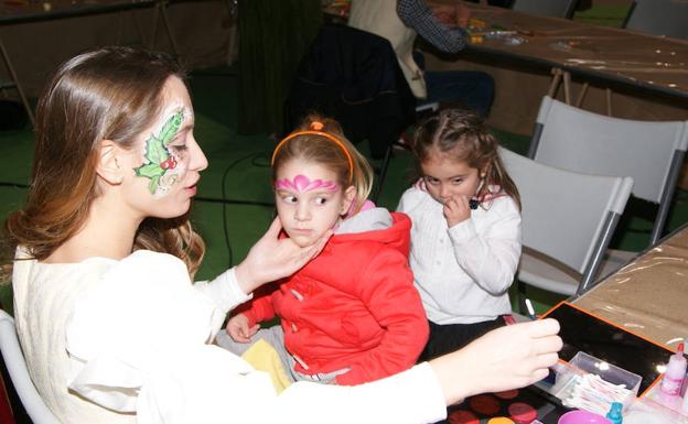 Las niñas disfrutan con el taller de pintacaras.