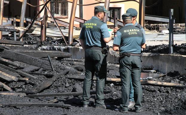 Agentes de la Guardia Civil inspeccionan el lugar donde tuvo lugar el incendio./Antonio Tanarro
