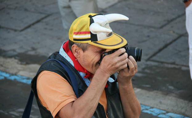 Un hombre hace una fotografía durante uno de los encierros de las pasadas fiestas.