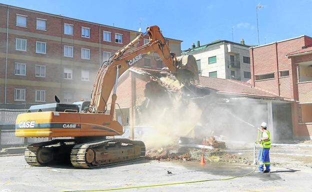 Una excavadora echa abajo parte de un tejado del antiguo colegio Victoria Adrados.