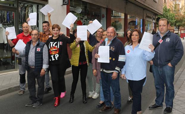 Comerciantes del entorno del Mercado del Val muestran las firmas recogidas. /H. SASTRE