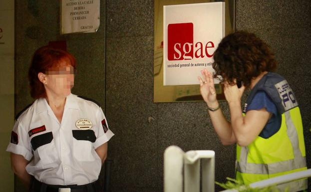 Agente de policía entra en la sede de la SGAE. /Luis Millán (Efe)