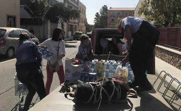 Algunas personas entregan alimentos de primera necesidad a la puerta del colegio San Francisco. /S.G.