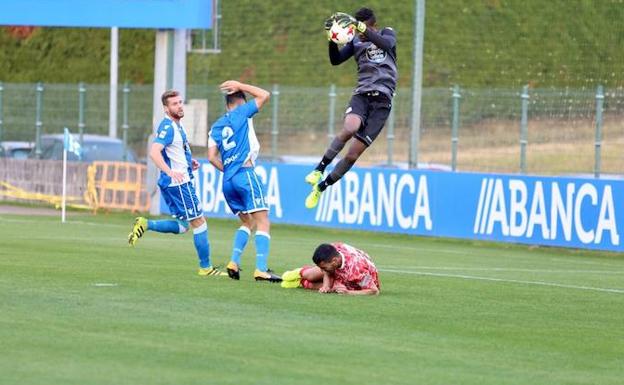 El meta del Fabril atrapa un balón aéreo con el delantero chacinero Pino en el suelo./CD GUIJUELO