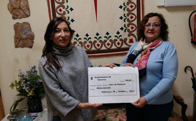 La presidenta de la asociación, a la derecha, sujeta el cheque con la concejala de Cisneros. /El Norte