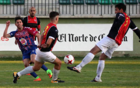 Fernán intenta un pase entre dos jugadores del Unión Adarve./Antonio de Torre