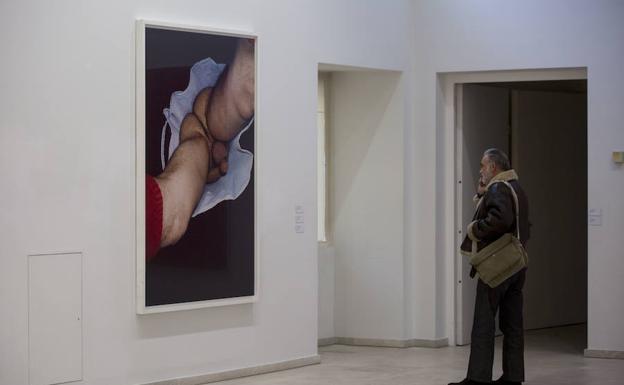 Un visitante observa uno de los cuadros recogidos en la muestra.