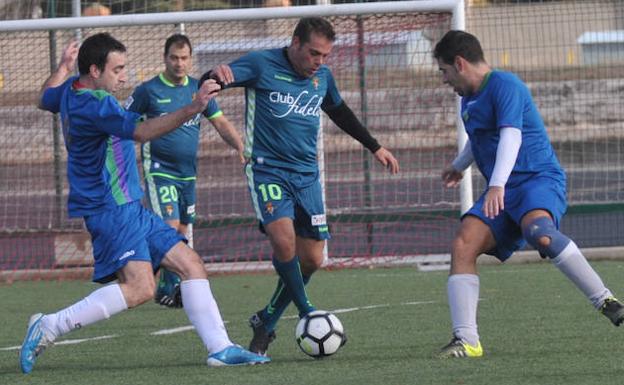 Chuchi Macón lleva el balón entre dos jugadores de los veteranos del Rondilla./Rodrigo Jiménez