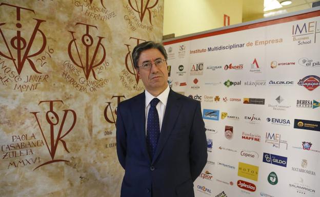 Julio Pindado posa ante una pared adornada con vítores./Manuel Laya