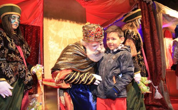 El rey Melchor escucha las peticiones de un niño en la Cabalgata de 2016. /Antonio Tanarro