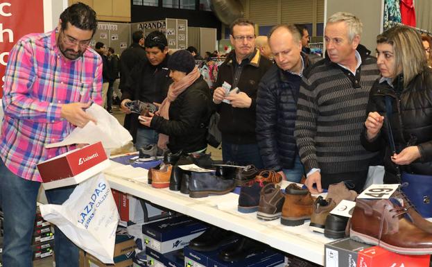 Varios visitantes observan los productos de calzado de uno de los expositores durante el fin de semana./Henar Sastre