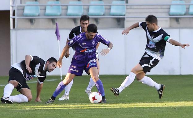 Zubi protege el esférico entre tres jugadores del Becerril en el partido de ida en La Balastera. /MARTA MORAS