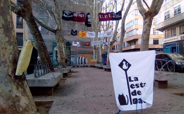 Carteles en agradecimiento a los comercios colaboradores, sobre las ramas de los árboles de la plaza.