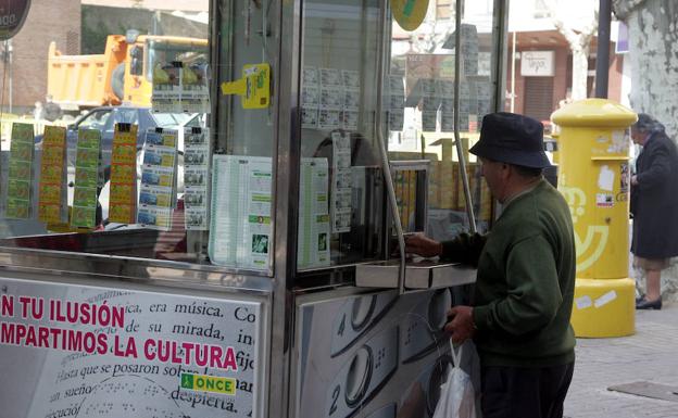 Un hombre compra un décimo en un quiosco de la ONCE./EL NORTE