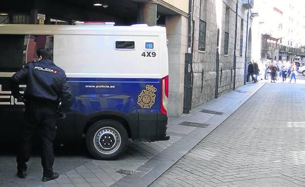 El furgón con los detenidos entra en el juzgado, con los familiares al fondo./J. S.