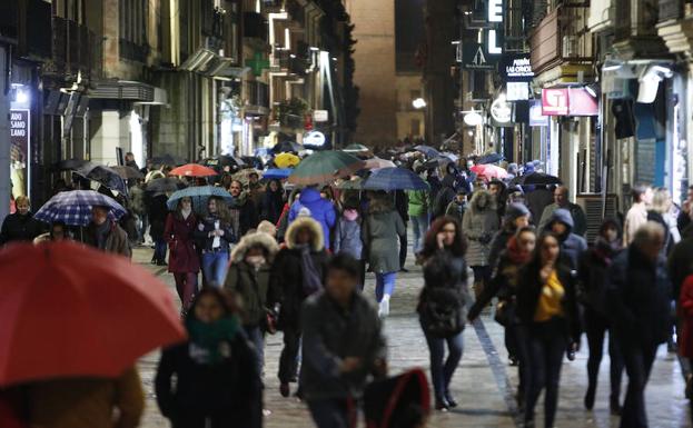 Viandantes refugiándose de la lluvia durante el Jueves Santo./LAYA