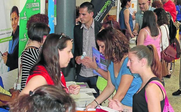 Varios jóvenes solicitan información en un stand durante una feria anterior. /A. de Torre