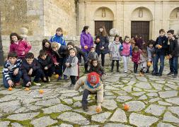 Niños de Carrión 'ruedan' las naranjas, a la puerta de la iglesia de Santa Clara. / GRAND/