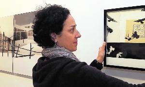 Mónica Gener cuelga una de sus obras en la sala de exposiciones del Palacio de Pimentel. / Henar Sastre/