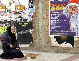 Una mendiga pide limosna en Málaga durante unas navidades. :: FERNANDO GONZÁLEZ/