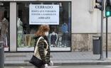 Una mujer pasa frente a un comercio cerrado en Valladolid./Gabriel Villamil