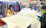 Dos operarios fabrican batas en la firma Raibowwear de material deportivo personalizado en La Cistérniga./El Norte