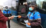 Policías locales reparten mascarillas a la puerta del autobús./A. Tanarro